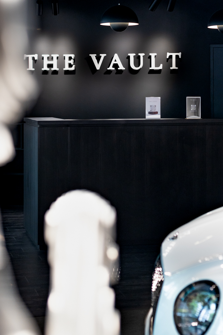 The Vault — Le comptoir de réception, lettrage blanc sur mur noir